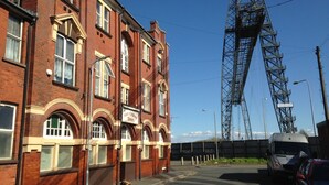 En rødstensejendom med et skilt, der viser 'West of England Tavern'.