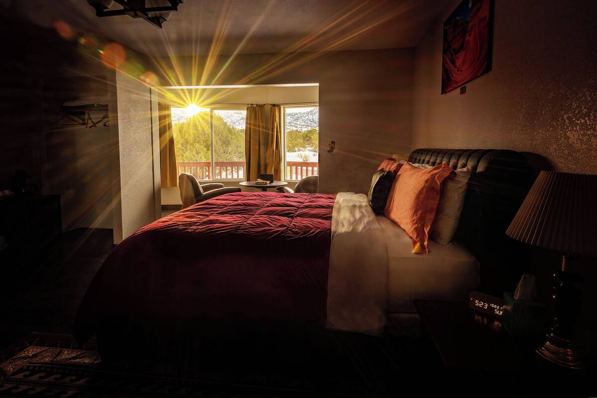 Una habitación de hotel con una cama, un escritorio y vistas al exterior.