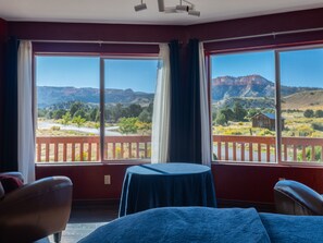 Habitación con un amplio ventanal que ofrece vistas a un paisaje montañoso.