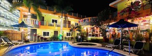 Una piscina al aire libre, sombrillas, sillones reclinables de piscina