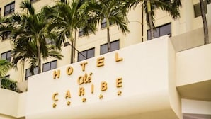 A couple walking towards a hotel entrance with a sign reading "HOTEL CARIBE." - Hotel Ole Caribe (Macuto)