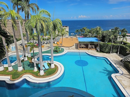Outdoor pool, open 7:00 AM to 7:00 PM, pool umbrellas, pool loungers. Hotel Ole Caribe