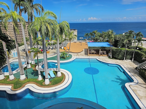 Piscine extérieure, parasols de plage, chaises longues