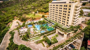 A hotel with a pool, surrounded by lush greenery and hills. - Hotel Ole Caribe (Macuto)