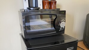 Cocina compacta equipada con microondas, cafetera y tarros de almacenamiento.