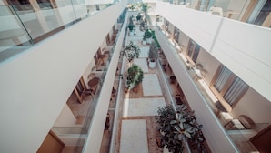 A multi-level atrium with glass railings, potted plants, and seating areas. -  Loa Tolú by Bernalo Hotels (Tolú)