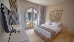 A hotel room with a bed, a desk with a computer, and a view of the outside balcony. -  Loa Tolú by Bernalo Hotels (Tolú)