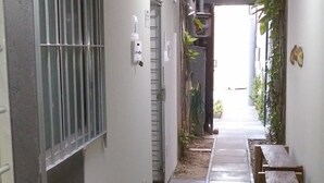 A hallway with a bench, a door, and a ceiling light. - Studio Boa Viagem (Recife)