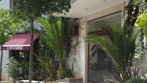 A building with a café named "CAFETERIA" and a staircase leading to the entrance. - Hotel San Blas (Abadino)