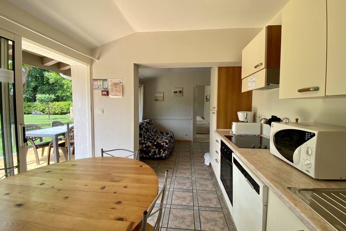 A compact kitchen with a dining area, a microwave, and a refrigerator.