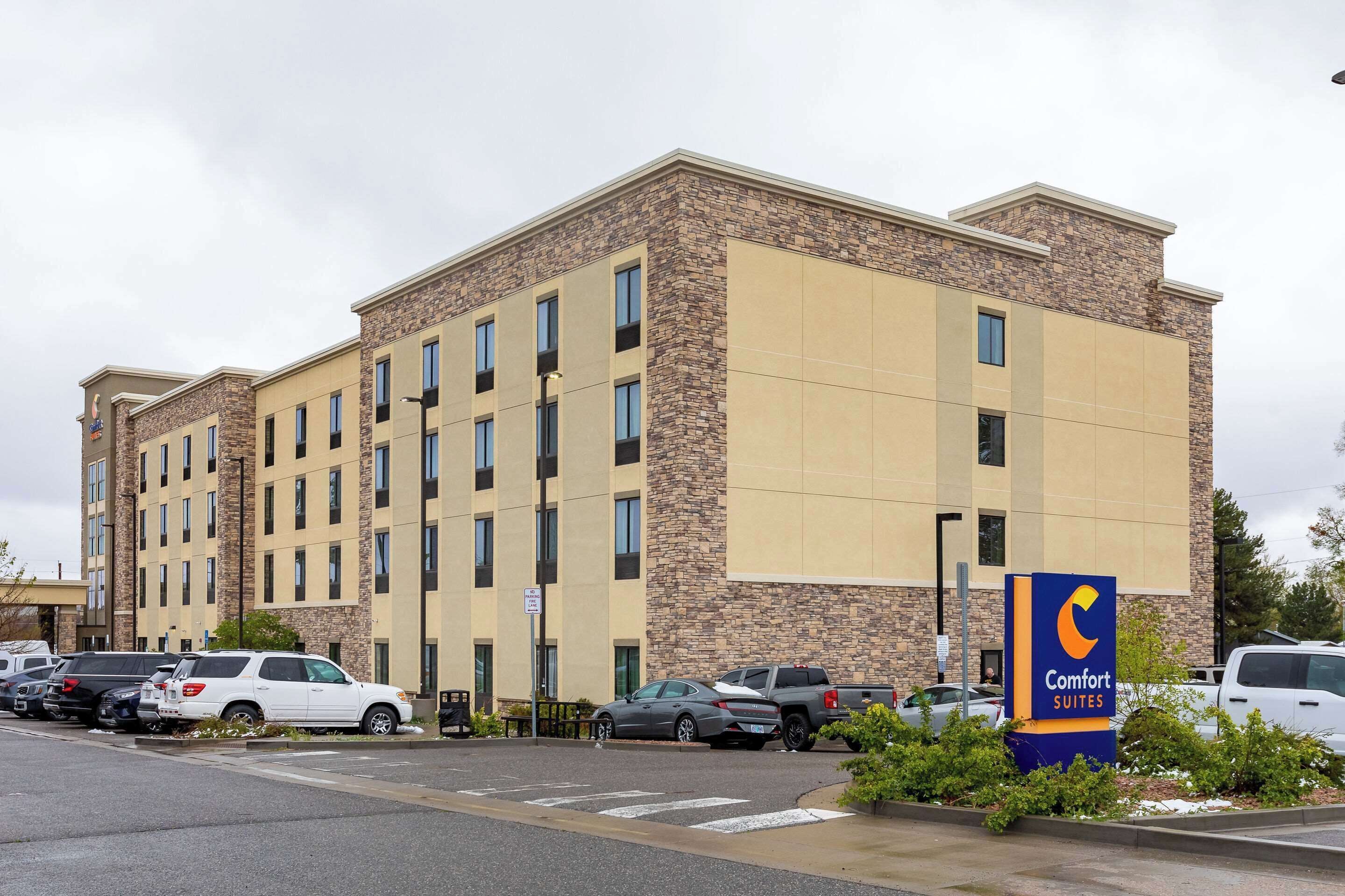 A multi-story hotel with a stone facade and a sign for Comfort Suites.