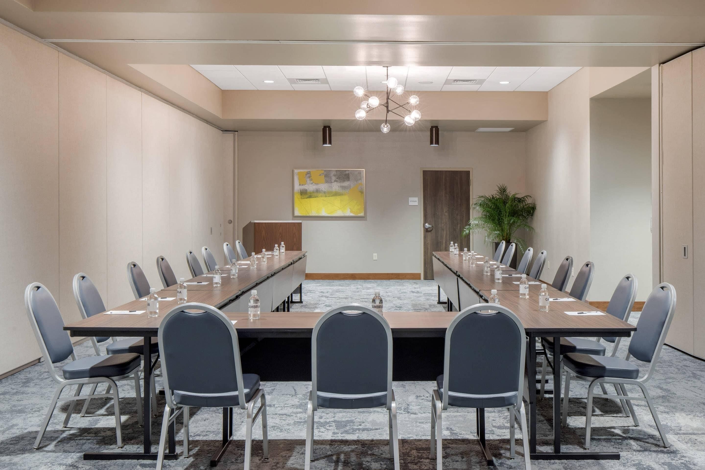 A conference room with a long table, chairs, and a chandelier.