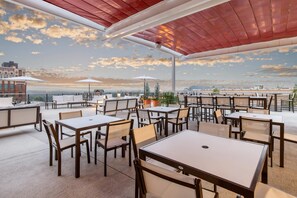 An outdoor patio with tables and chairs, umbrellas, and potted plants. - Cambria Hotel Downtown Asheville (Asheville)
