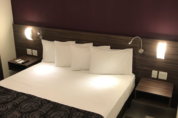 Quarto casal superior, 1 cama Queen | Frigobar, cofres nos quartos, escrivaninha, cortinas blackout