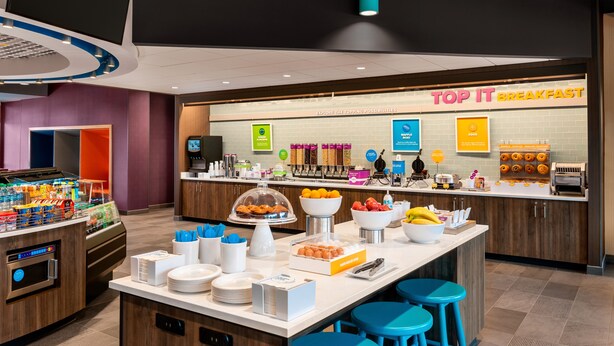 A breakfast area with a counter displaying various food items and a sign reading "TOP IT BREAKFAST". - Tru by Hilton Lancaster East (Lancaster)