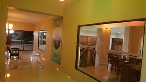 Un pasillo de hotel con un ventanal que muestra un comedor, un cartel con un globo terráqueo y un letrero que dice 'Global View'.