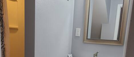 Une salle de bain avec un lavabo, un miroir et un meuble-lavabo.