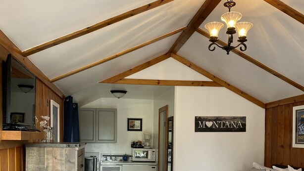 A cozy, rustic cabin with two bedrooms, a kitchenette, and a dining area. - Lamplighter Cabins & Suites (Helena)