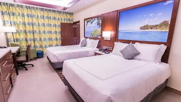 A hotel room with two beds, a desk, and a chair.