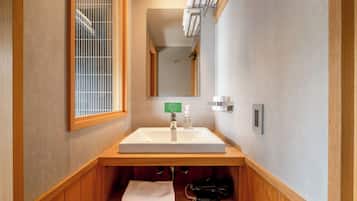 Un baño con tocador de madera, un espejo grande y una ventana con vistas.