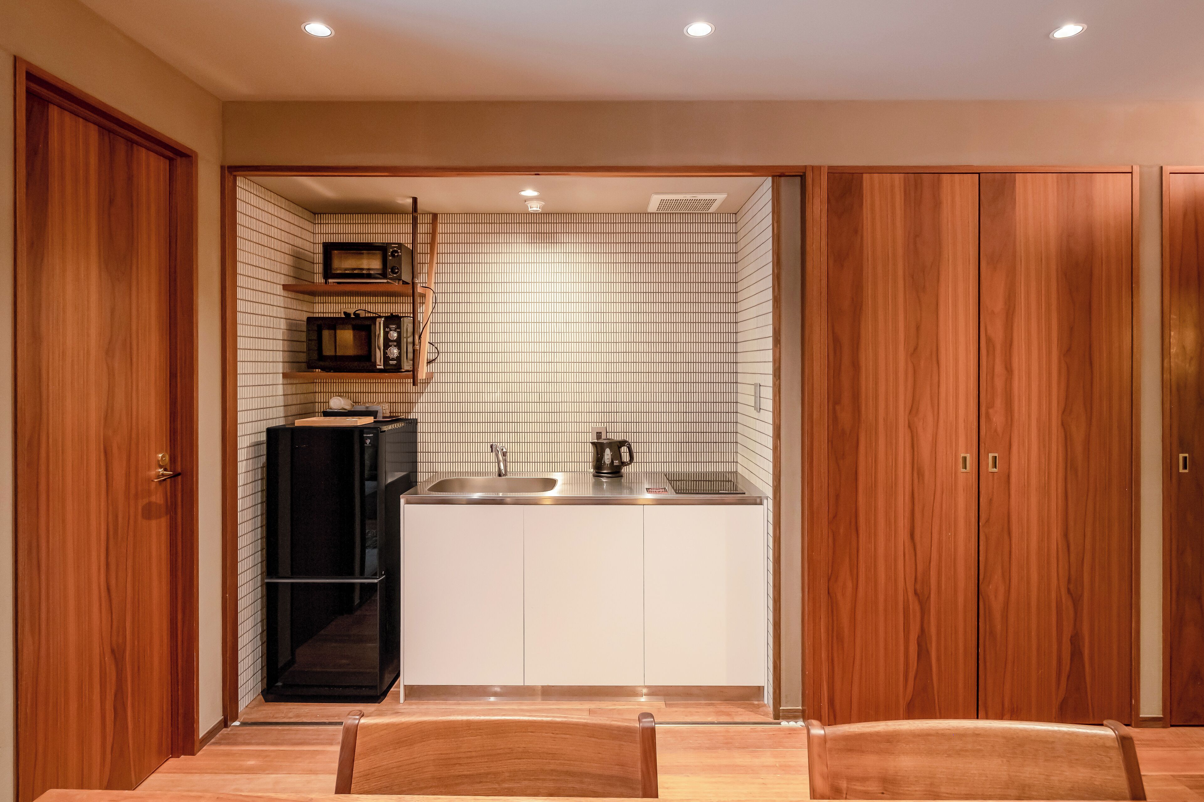 Una cocina compacta con microondas, fregadero y alacenas.