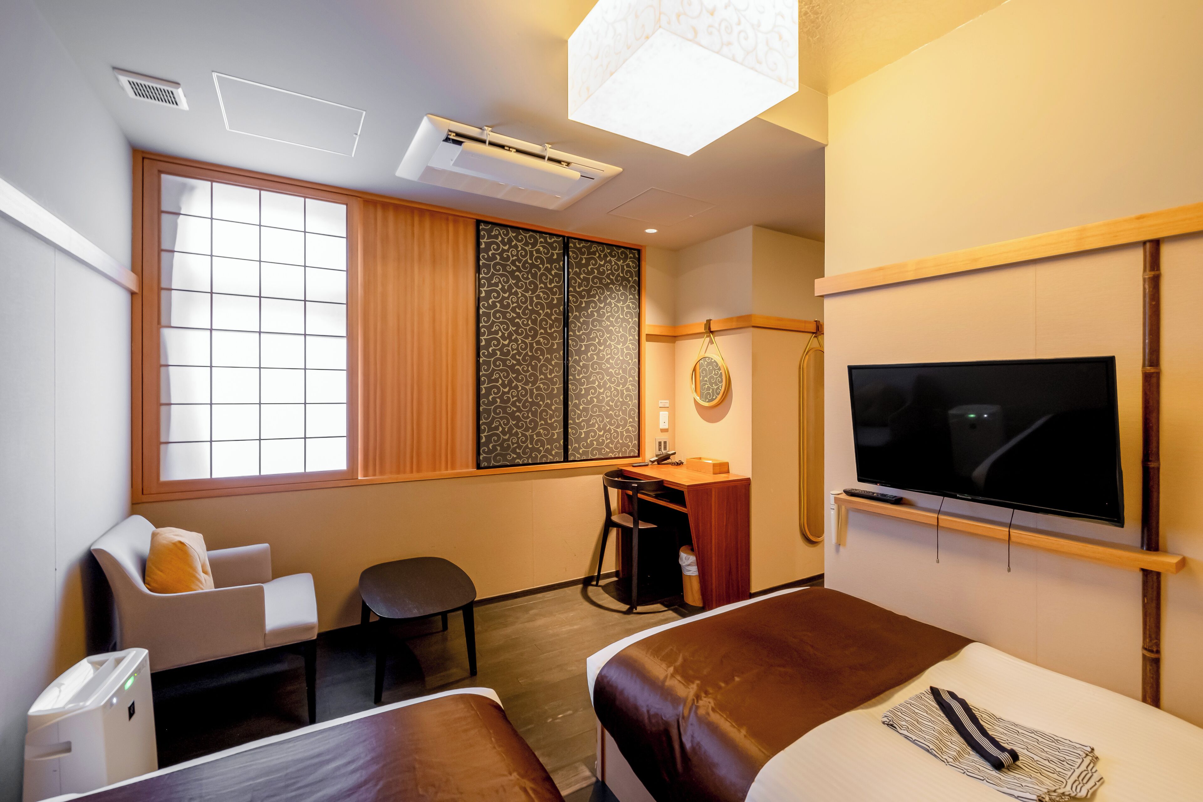 Ein Hotelzimmer mit Bett, Schreibtisch, Stuhl, Fernseher und einem Fenster mit Blick.