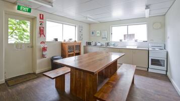 Una cocina con una mesa de madera, armarios, un microondas y un horno.