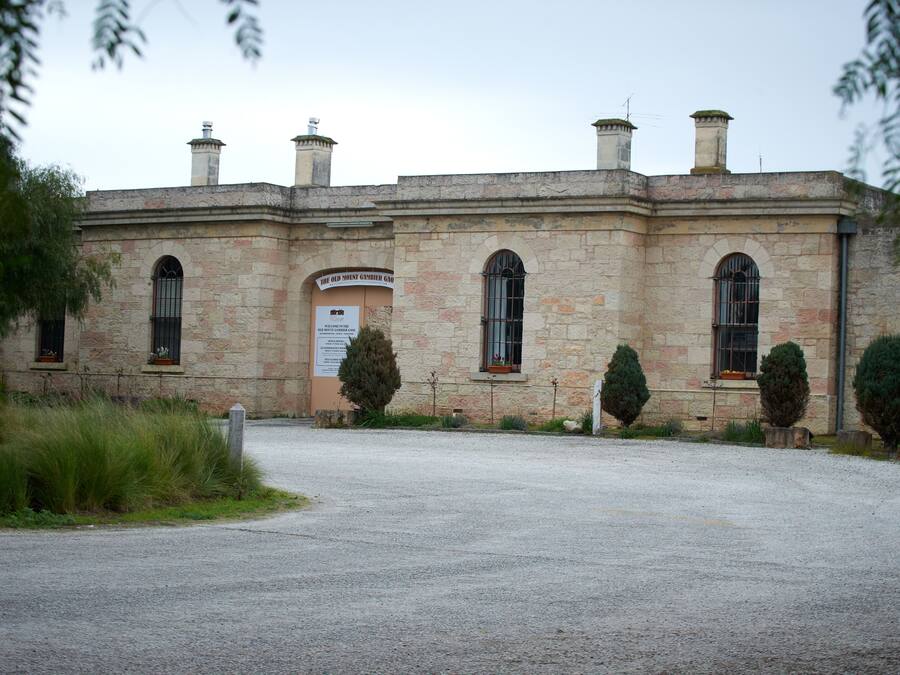 Un edificio de piedra histórico con ventanas arqueadas y un letrero que dice "The Old Mount Gunter Castle".