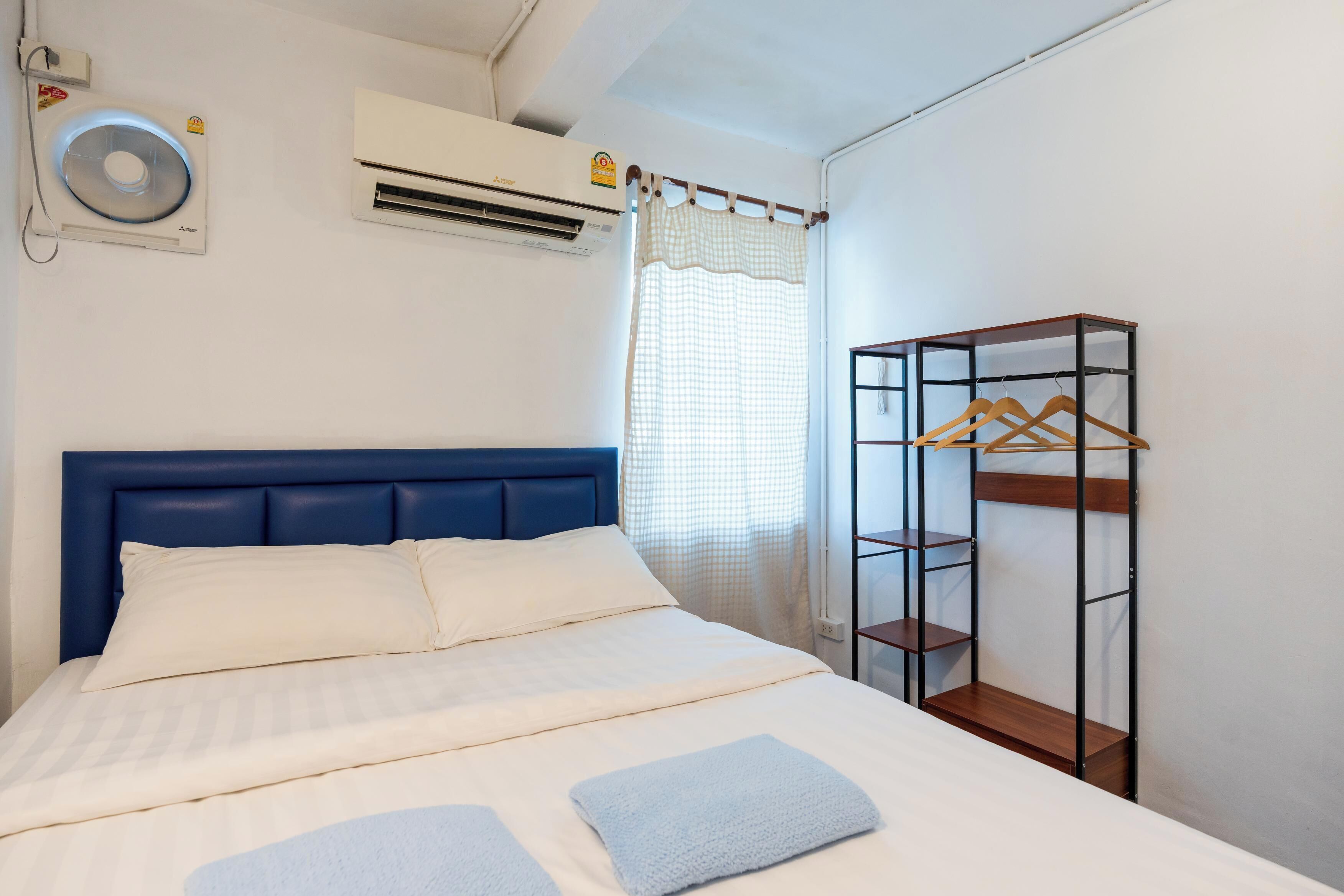 Quarto com cama, guarda-roupa e ar condicionado.