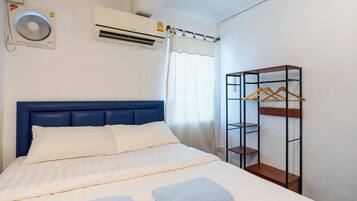 Quarto com cama, guarda-roupa e ar condicionado.