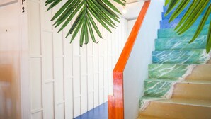 A staircase with a wooden handrail and a palm leaf decoration. - Arawana Hostel Silom (Bangkok)