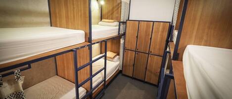 A bunk bed room with wooden walls and a small closet.