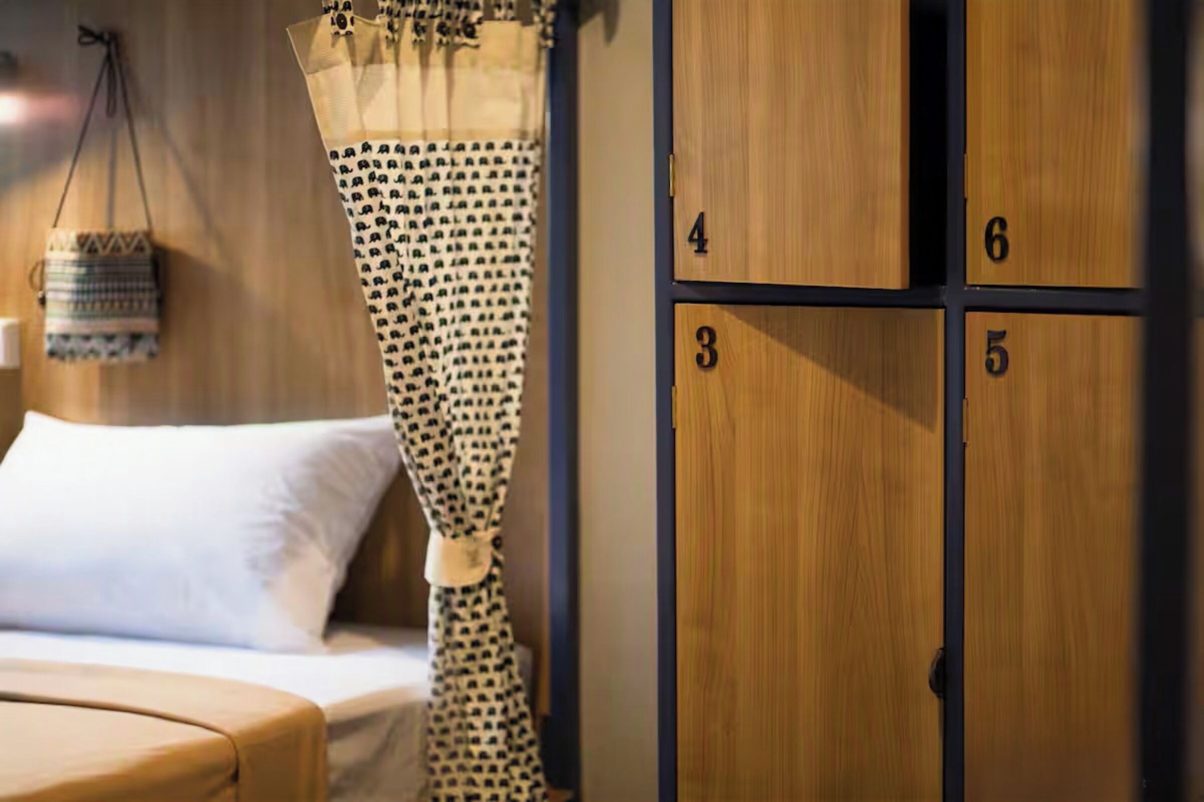 A bedroom with a bed, a hanging basket, and a wardrobe with numbered compartments.