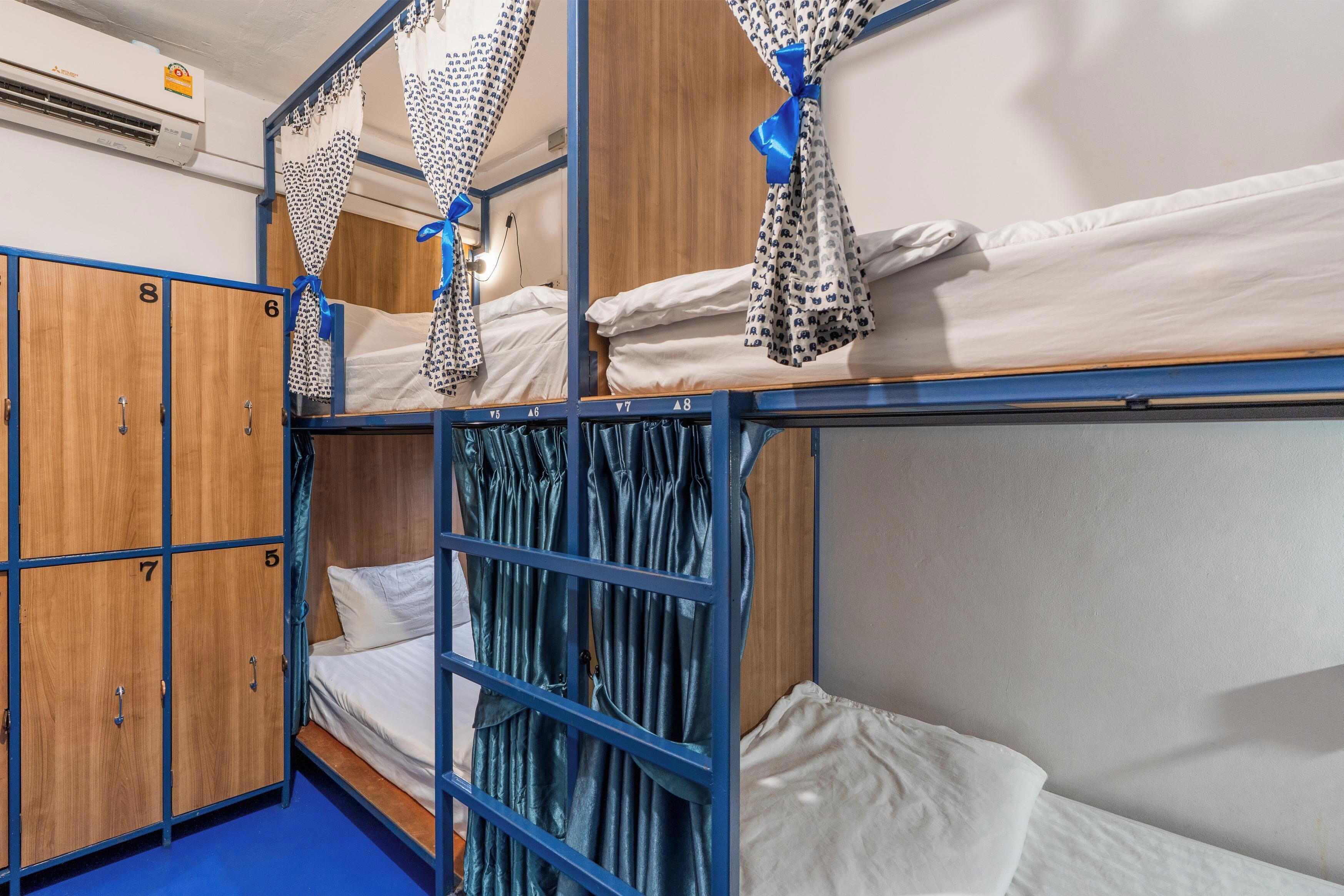 A bunk bed room with wooden lockers and a blue floor.