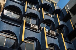 A multi-story building with balconies and air conditioning units. - Arawana Hostel Silom (Bangkok)