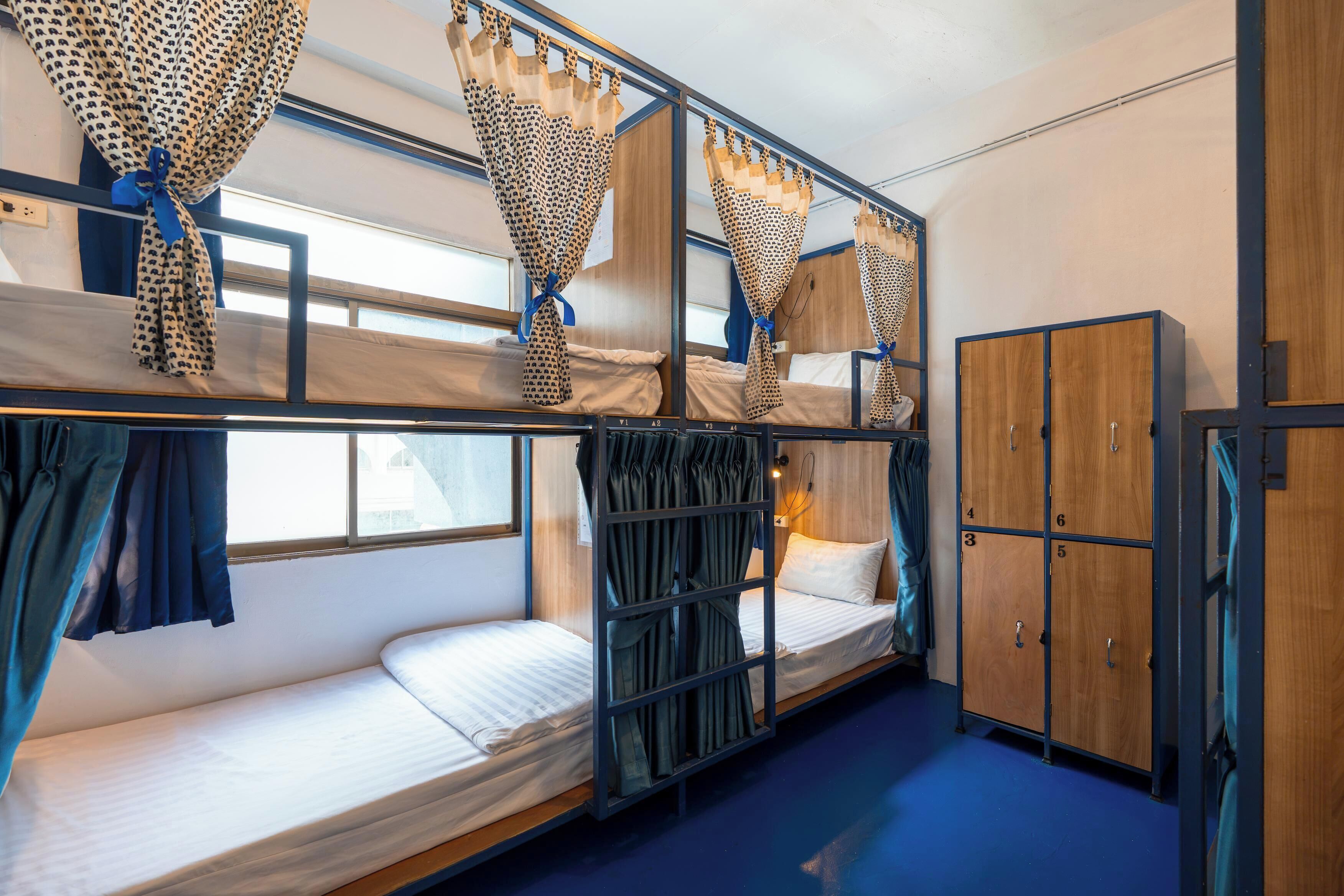 A bunk bed room with curtains, a wardrobe, and a window.