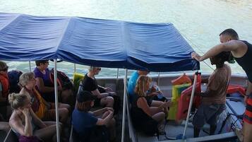 A boat with a blue canopy and passengers.