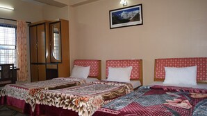 A hotel room with two beds, a wardrobe, and a framed picture on the wall. - Hotel The Beehive (Pokhara)