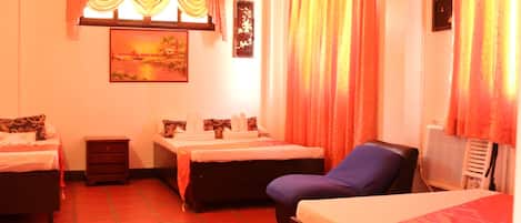 Una habitación de hotel con dos camas, una mesita, una silla y un cuadro en la pared.