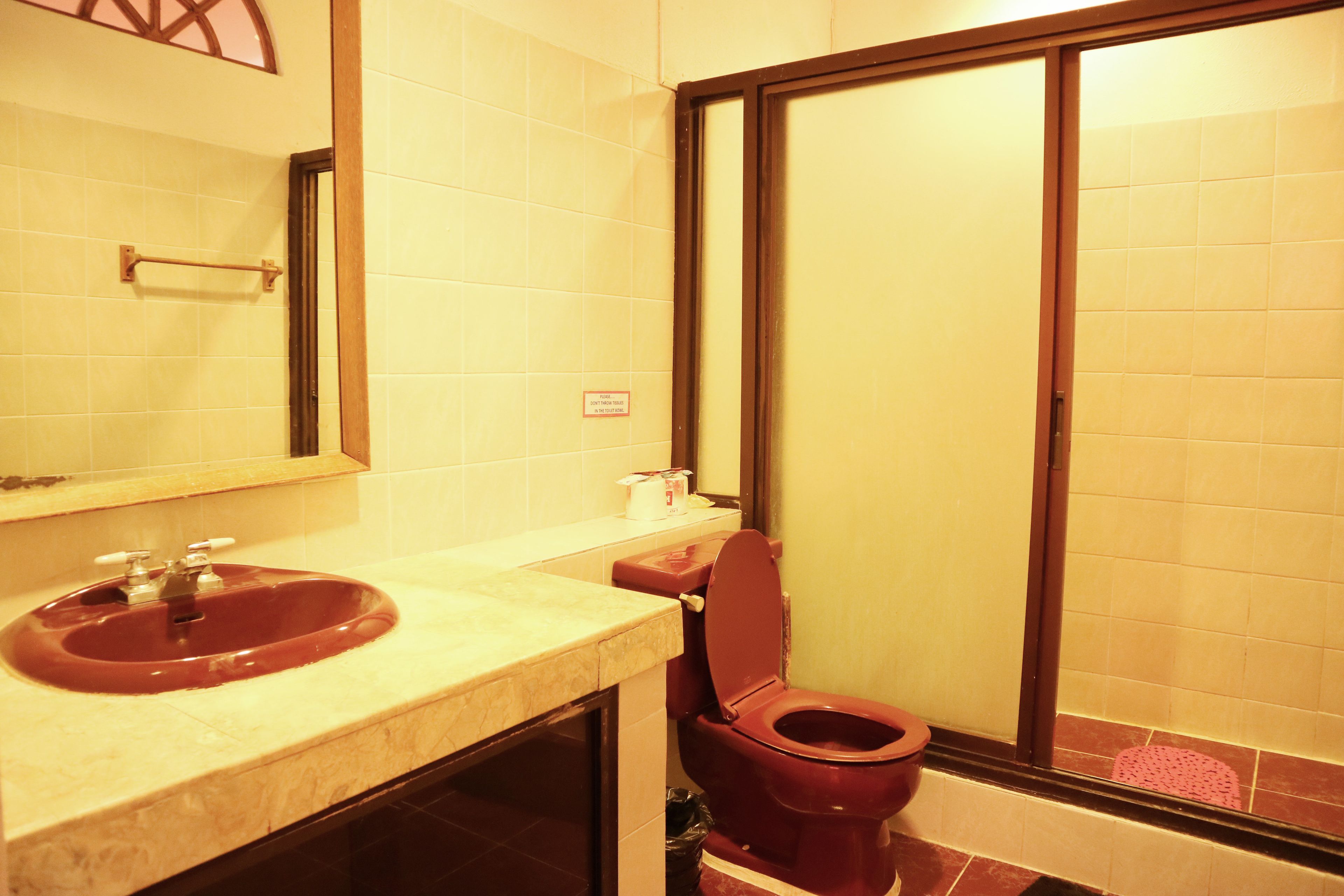 Ein Badezimmer mit Waschbecken, Toilette und einem Fenster.