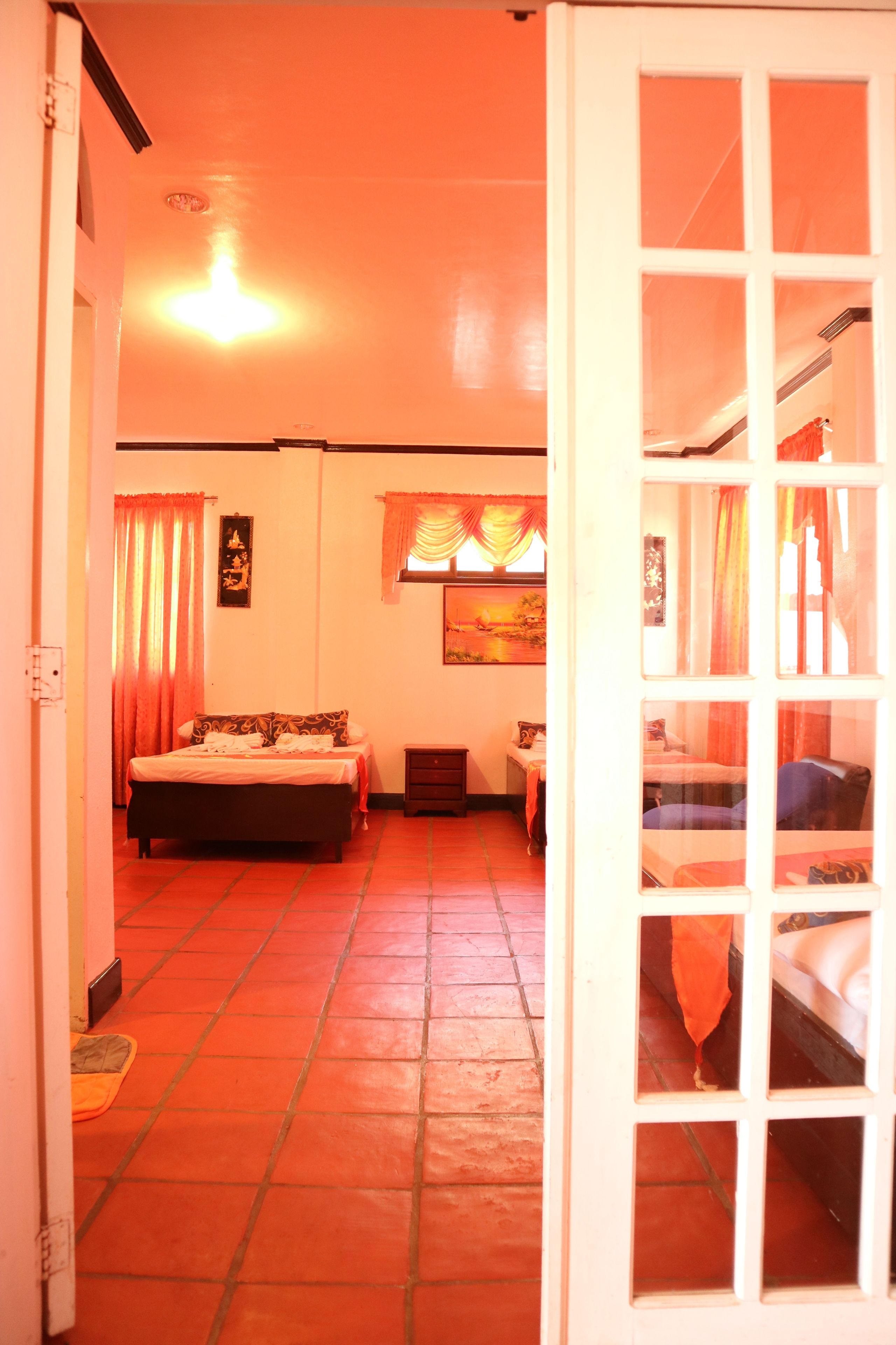 A hotel room with a bed, a desk, and a window with curtains.