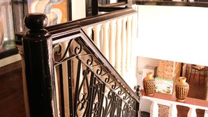 A staircase with a black balustrade, a wooden ceiling, and a brick floor. - Isla Bonita Beach Resort (San Juan)