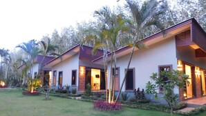 A modern hotel with multiple units, each featuring a balcony and a small garden area. - Phuket Sirinapha Resort (Sa Khu)