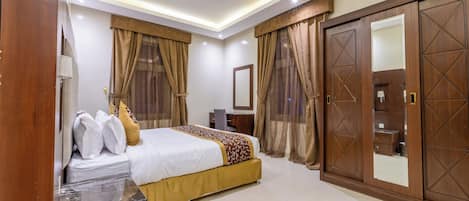 A hotel room with a bed, a desk, a wardrobe, and a bathroom.