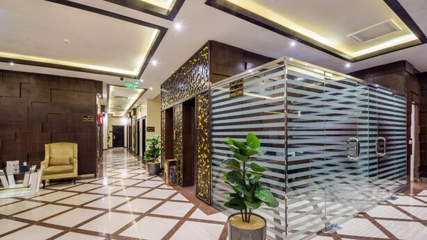 A hotel lobby with a check-in counter, a reception desk, and a glass partition with a decorative pattern. - Al Muhaidb Residence Al Malaz 1 - Economic (Riyadh)
