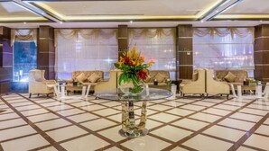 A spacious lobby with a central glass table, multiple sofas, and a large window with curtains. - Al Muhaidb Residence Al Malaz 1 - Economic (Riyadh)