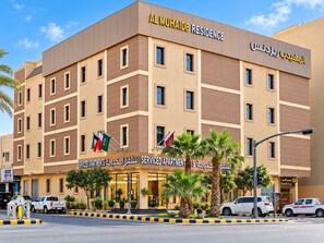 A multi-story serviced apartment building with a modern design, multiple balconies, and a parking area in front. - Al Muhaidb Residence Al Malaz 1 - Economic (Riyadh)
