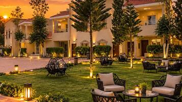A hotel courtyard with outdoor seating and a sunset view.