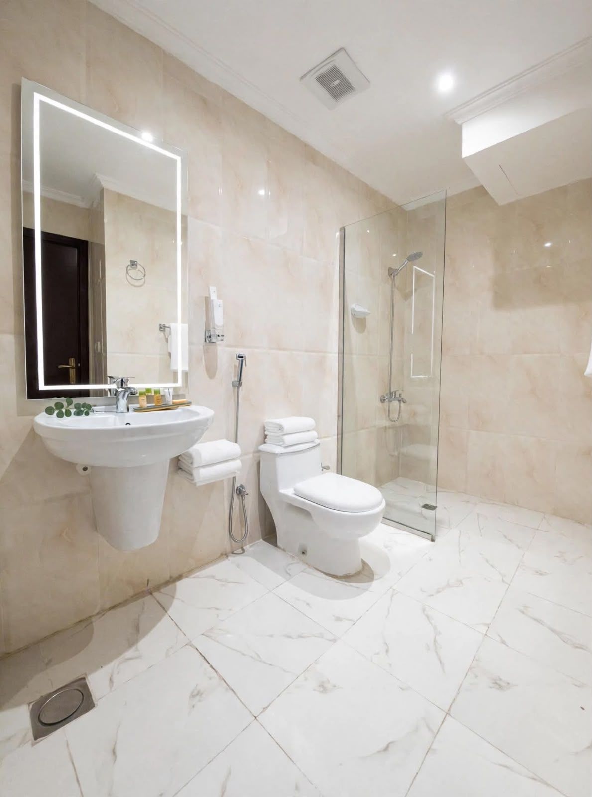 A modern bathroom with a large mirror, a sink, a toilet, and a glass-enclosed shower.