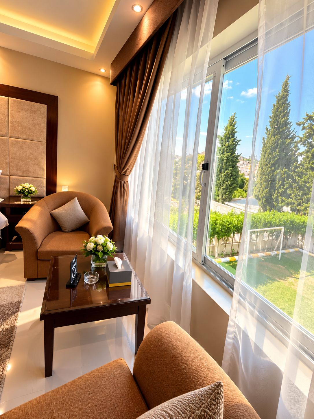 A modern living room with a sofa, a coffee table, and a view of a garden through large windows.
